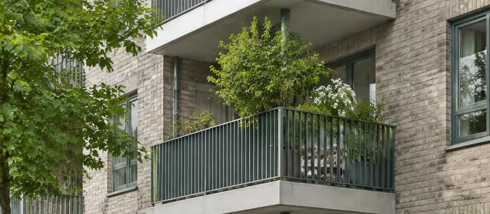 Appartementengebouw met balkons en een groene tuin